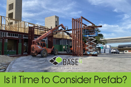 Construction site with prefab steel structures and a telehandler, highlighting BASE4's innovative building solutions